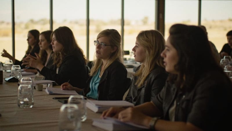 Candidatas sentadas en una mesa de convivencia durante taller de preparación en Camargo