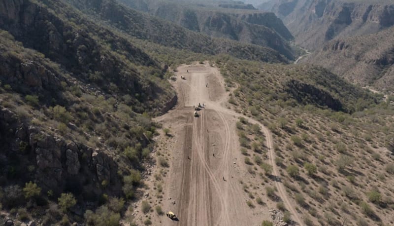 Terreno montañoso con una pista de tierra que es inutilizada por elementos de seguridad en la serranía
