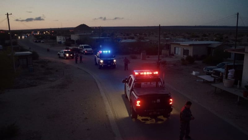 Operativo de seguridad con luces de emergencia en una calle fronteriza del desierto chihuahuense