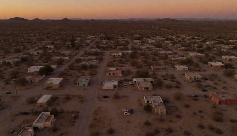 Paisaje desértico del norte de México con pueblo pequeño entre cerros al atardecer