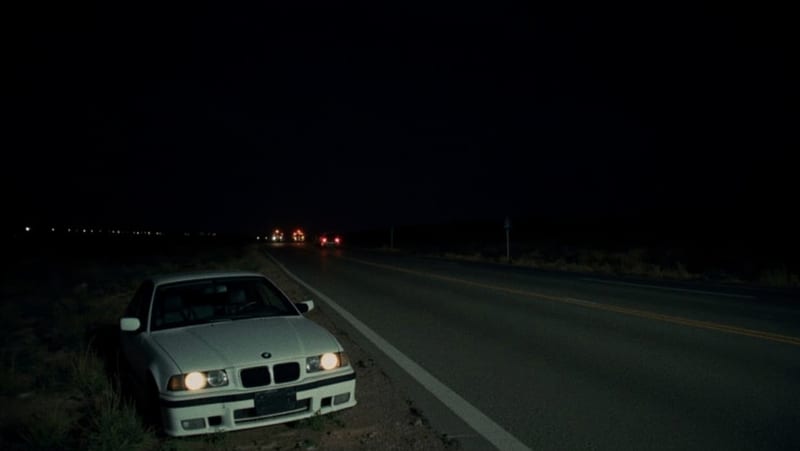 BMW blanco abandonado en la orilla de una carretera rural del norte de México al anochecer