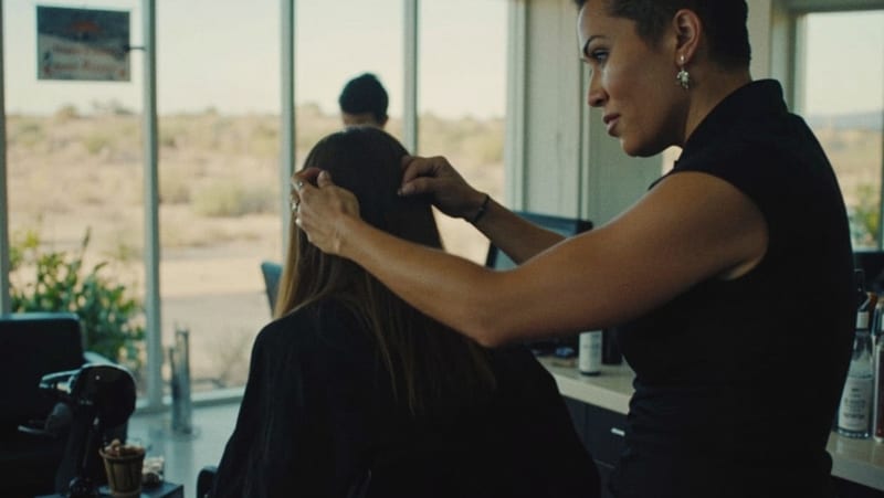Instructora aplicando tratamiento de keratina en el cabello de una participante dentro de un salón de belleza