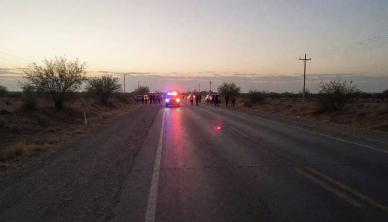 Carretera rural al amanecer con luces de emergencia parpadeando en el horizonte del desierto chihuahuense