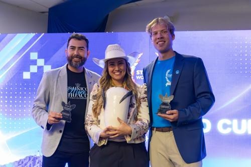 Mayra Hurtado Terminel sostiene el trofeo de la Startup World Cup junto a Ricardo Bustos y Jake Schiller