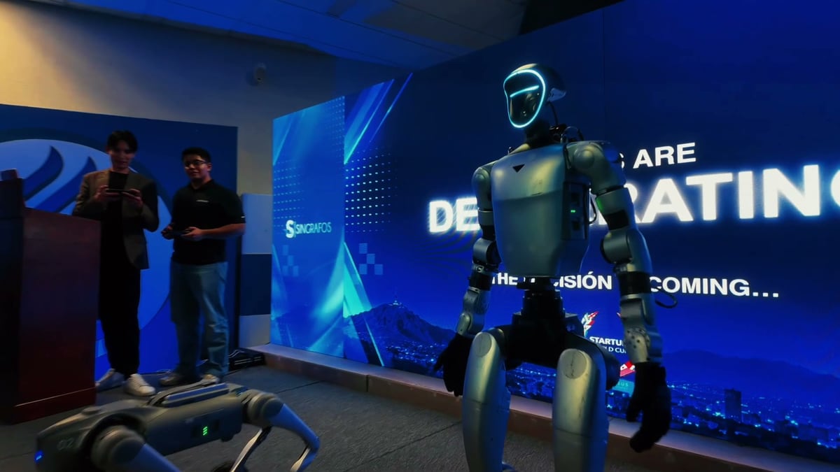 Un robot humanoide en el escenario frente a la pantalla que anuncia que el jurado está deliberando