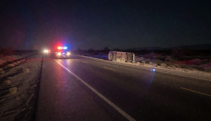 Vehículo volcado de noche en la carretera con luces de emergencia iluminando la escena