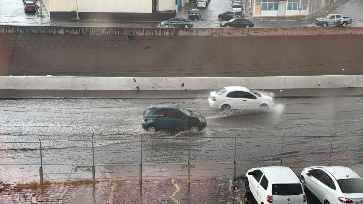 Autos cruzan una vialidad inundada en Chihuahua capital