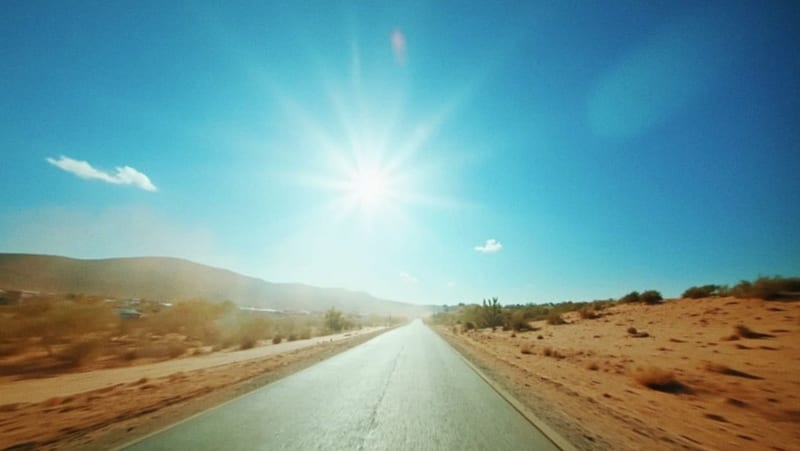 Calle árida bajo el intenso sol del mediodía en un paisaje desértico de la capital chihuahua