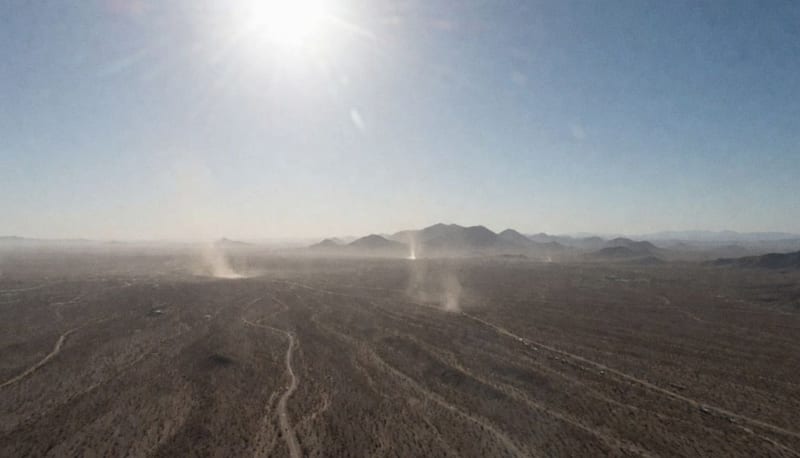 Paisaje desértico de Chihuahua bajo intenso calor con polvareda y horizonte borroso