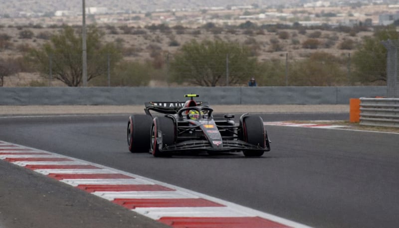 Automóvil de carreras color plateado en movimiento sobre una pista de competición