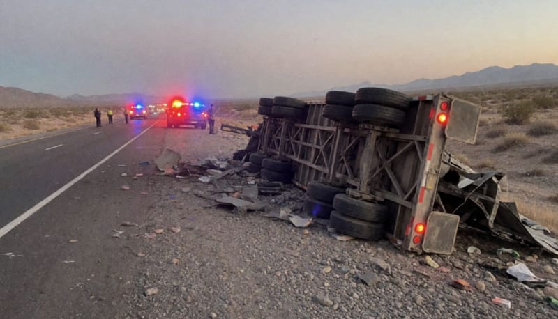 Tráiler volcado sobre el terreno desértico de la carretera Chihuahua-Delicias al atardecer con luces de emergencia
