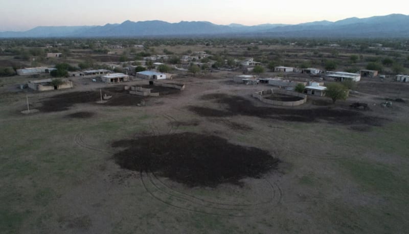 Vista aérea de terrenos rurales agrícolas en el norte de México con edificios dispersos y campo abierto al atardecer